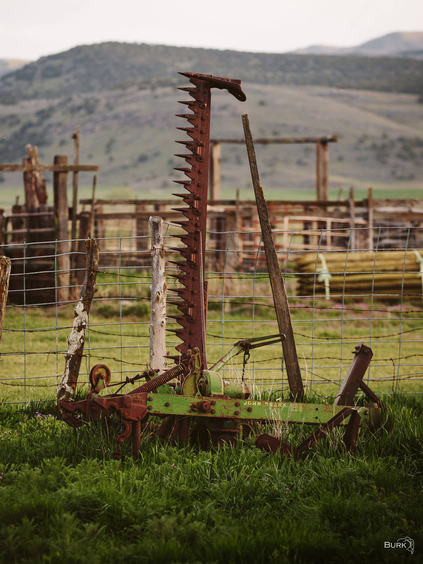 Ghost of the Hayfield A old sickle bar mower—a piece of farm equipment used for cutting grass, hay, or small crops.