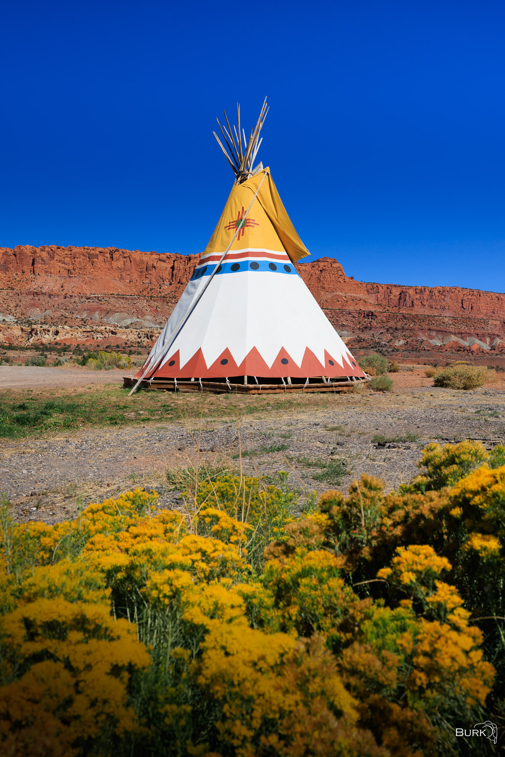 Desert Tipi A traditional tipi stands beneath the red rock cliffs of Utah’s desert landscape.